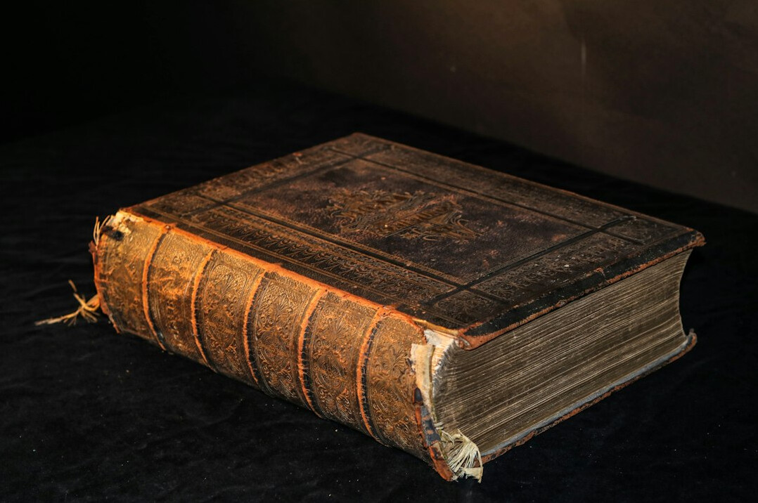 Pila de libros antiguos sobre una mesa de madera